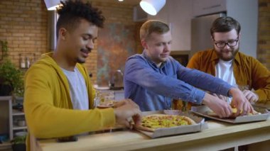 Çok ırklı bir arkadaş grubu evde lezzetli pizzalar yiyor, hafta sonu tatili...