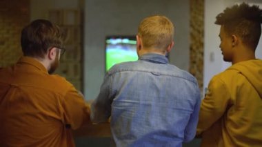 Futbol taraftarları TV 'de maç izliyor, bardakları tokuşturuyor, takımı destekliyor.