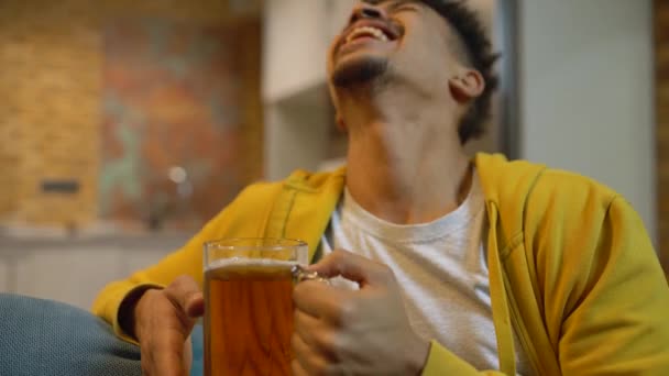 Три друга-мужчины звонят в пивные бокалы и смеются, наслаждаясь праздничной атмосферой — стоковое видео