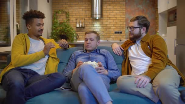Hombres amigos masticando palomitas de maíz y hablando, disfrutando de la comunicación en vivo en la fiesta — Vídeo de stock