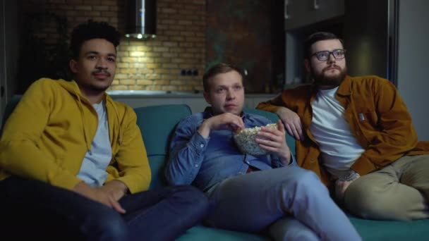 Male friends shocked by scary movie, watching tv together at home, leisure — Stock Video