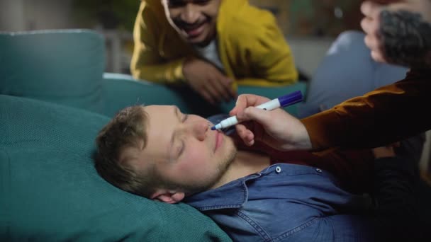 Amigos masculinos brincando com seu amigo dormindo após a festa do álcool, vida estudantil — Vídeo de Stock