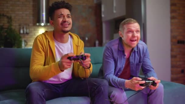 Two guys actively playing video game with joysticks, friends having fun together — Stock Video