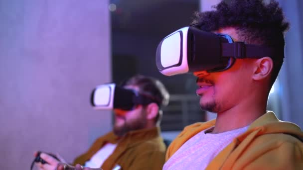 VR kulaklıkla video oyunu oynayan iki oyuncu, rekabet stratejisini tartışıyor — Stok video