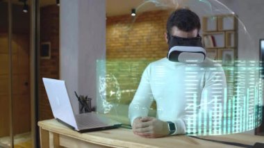 VR seti, fütüristik teknoloji, hologram ve AR kullanan adam mali tabloları inceliyor.