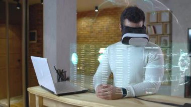 Tıbbi hologramları inceleyen, video seti takan, okuyan, uzaktan çalışan genç bir adam.