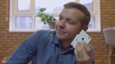 Mutlu genç adam iki as gösteriyor, kazanan el ele tutuşuyor, poker oyunu zaferi.