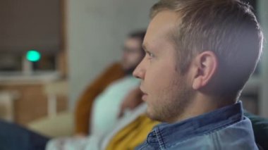 Genç beyaz erkek bağırıyor, futbol takımı için tezahürat yapıyor, arkadaşları eğleniyor.