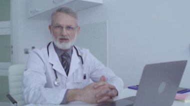 Profesyonel kıdemli doktor hastanede hastayla konuşuyor, sağlık hizmetleri...