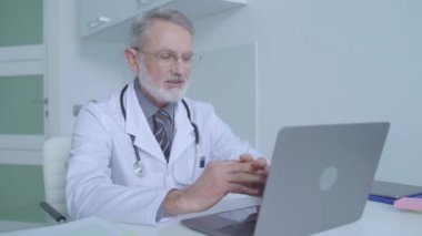 Erkek doktor hastasıyla çevrimiçi konferans görüşmesi yapıyor. Tıbbi danışma.
