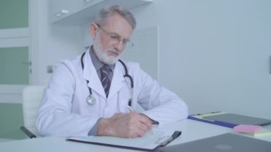 Tıbbi belgelerde teşhis koyan ciddi bir doktor, klinikte danışmanlık