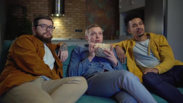 Vyděšení mladí muži sledující horor doma, přátelé tráví čas spolu — Stock video