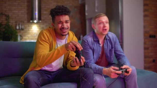 Zwei männliche Freunde spielen Videospiel zu Hause, Freundschaft zu zweit, Hobby — Stockvideo