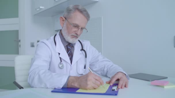 Male pediatrician writing medical prescription for patient, healthcare services — Stock Video