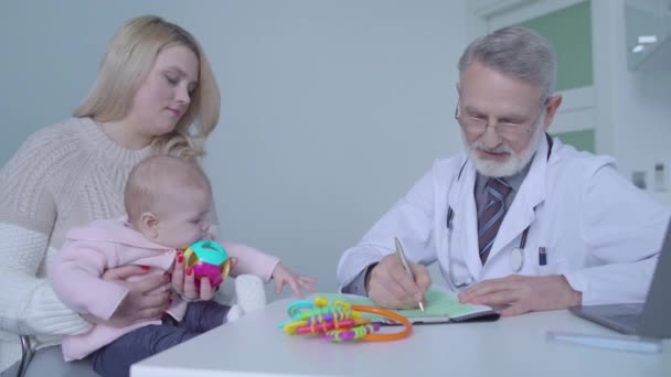 Junge Frau besucht Arzt mit Baby zur regelmäßigen Gesundheitsprüfung, Medizin — Stockvideo