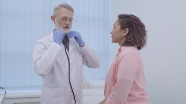 Terapista esperto in stetoscopio che esamina il torace del paziente, controllo medico — Video Stock