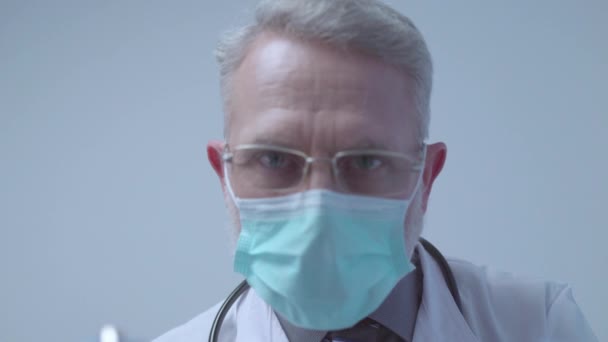 Männlich Arzt mit Brille und Schutzmaske Blick auf Kamera, pov des Patienten — Stockvideo