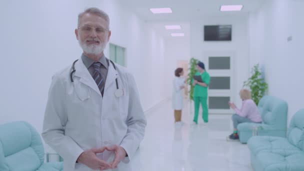 Terapeuta sonriente en bata de laboratorio mirando a la cámara, personal médico profesional — Vídeos de Stock