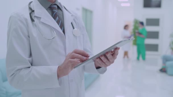 Physician scrolling tablet, using medical application, checking analysis online — Stock Video