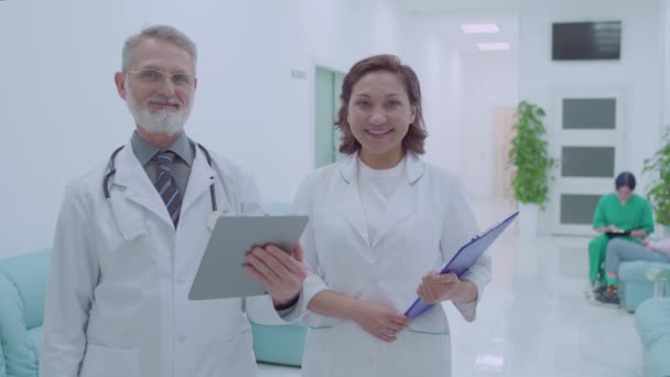 Profesionální lékaři při pohledu do kamery, nemocniční služby, klinika — Stock video