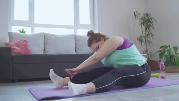 Overgewicht jonge vrouw oefenen op mat thuis, hard werken om gewicht te verliezen — Stockvideo