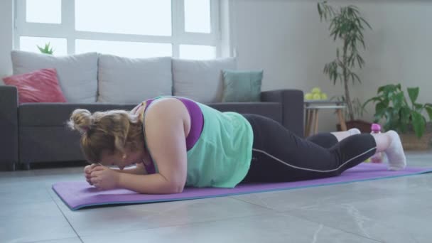 Menina com excesso de peso não consegue fazer exercício de prancha, caindo no chão, chateado com a obesidade — Vídeo de Stock