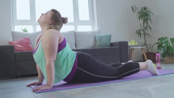 Moe van obese jonge vrouw doen stretching oefeningen thuis, gewichtsverlies training — Stockvideo