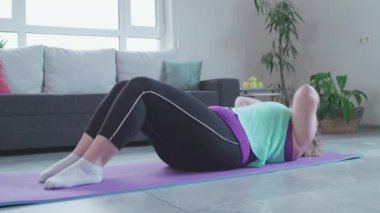 Kilolu kız göbek yağlarını atmak için evde egzersiz yapıyor, obeziteyle savaşmak için çok çalışıyor.