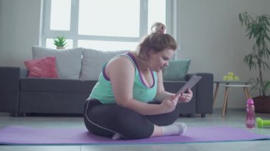 Sağlıklı yaşam tarzı tavsiyelerine şaşırmış, tablete bakan heyecanlı şişman kız.