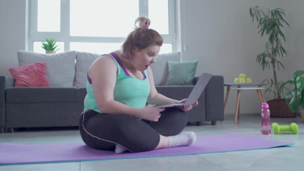 Verrast mollige vrouw op zoek naar laptop scherm, enthousiast over gewichtsverlies tips — Stockvideo