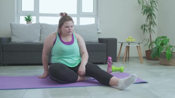 Избыточный вес молодая женщина, испытывающая боль в груди после тренировки дома, плохое здоровье — стоковое видео