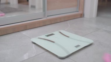 Yerdeki elektronik terazide duran kadın bacakları, ağırlığı ölçen kadın.