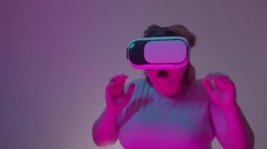 Şok olmuş, VR kulaklık takan kadın simülasyon oyunu oynuyor, artırılmış gerçeklik.