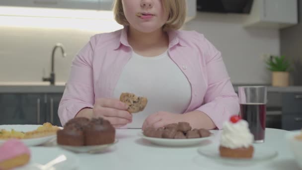 Överviktig dam äter kaka, söta desserter på bordet, risk för diabetes — Stockvideo