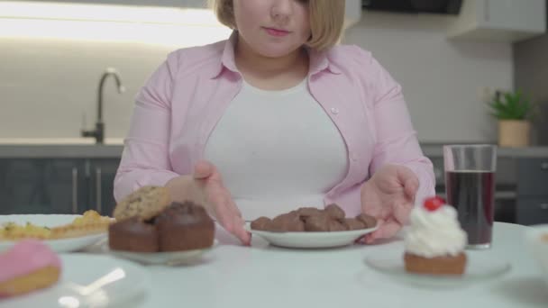 Mujer de tamaño grande comiendo dulces de chocolate y bebidas gaseosas, adicción al azúcar, dieta — Vídeos de Stock