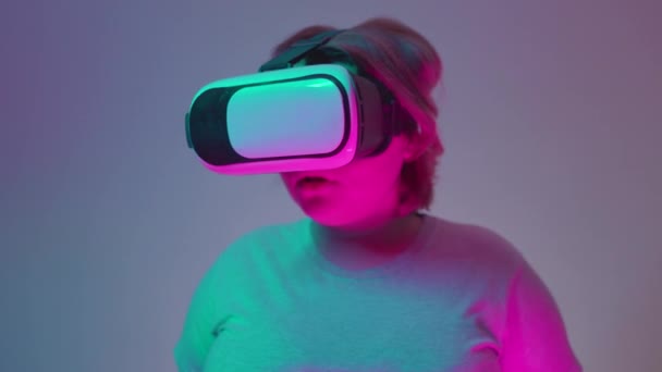 Удивлённая девушка-подросток в наушниках виртуальной реальности, инновациях будущего — стоковое видео