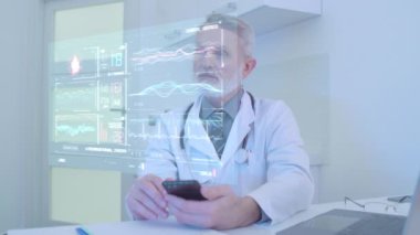 Doktor, hastanın hayati belirtilerini uzaktan kontrol ediyor. Gelecekteki holografik istatistikler.
