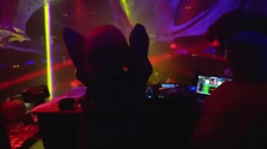 Kaygısız kadın DJ müzik dinliyor, gece kulübünde dans ediyor.