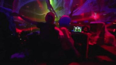 Müzik eşliğinde dans eden iki diskjokey DJ 'in yanında duruyor.