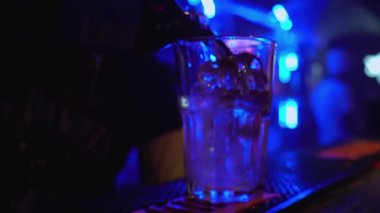Barmen buzlu bardağa Wiskey döker, gece kulübünde kokteyl yapar, parti yapar.