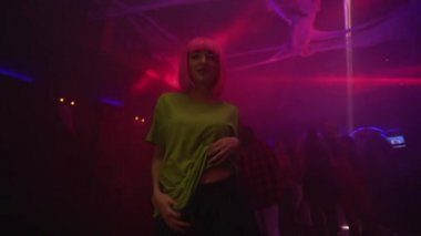 Çekici kadın, baştan çıkarıcı bir şekilde müzikle ilgileniyor, kameraya bakıyor, gece hayatı tarzında.