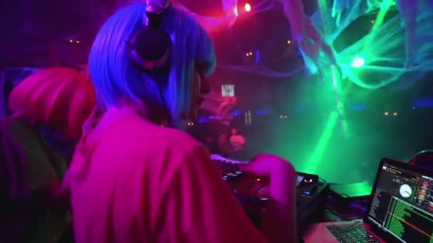 Клуб діджея в навушниках, що працюють на обертальному столі, граючи музику на фестивалі, професія — стокове відео