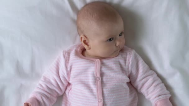 Lieve pasgeboren baby liggend op bed, schattige baby gezicht close-up, kindertijd — Stockvideo