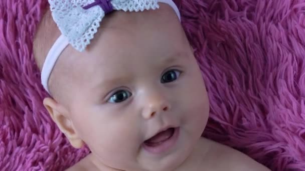 Lieve baby liggend op roze deken, onschuldige blik op zoete zuigeling gezicht close-up — Stockvideo