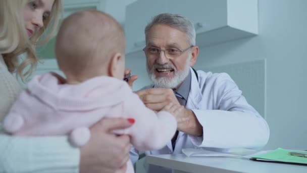 Семейный врач обследование активного ребенка на клинике, посещение педиатра, здравоохранение — стоковое видео