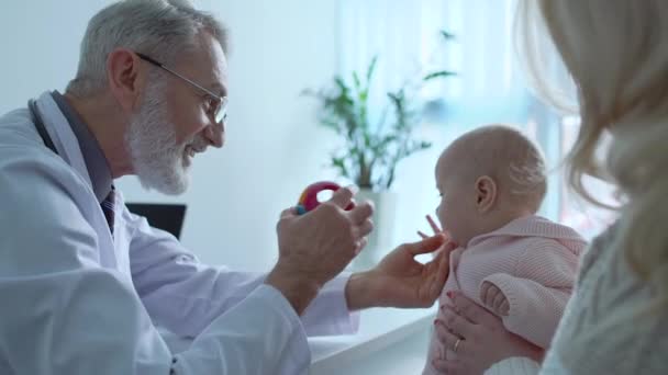 Έμπειρος παιδίατρος που δείχνει παιχνίδι στο μωρό, τακτικός έλεγχος υγείας, ιατρική — Αρχείο Βίντεο