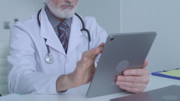 Medical specialist scrolling images on tablet, examining patient's analysis, app — Stock Video