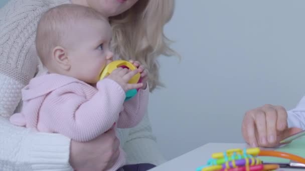 小児科医が赤ちゃんの母親と話をして医師の診察を受ける — ストック動画