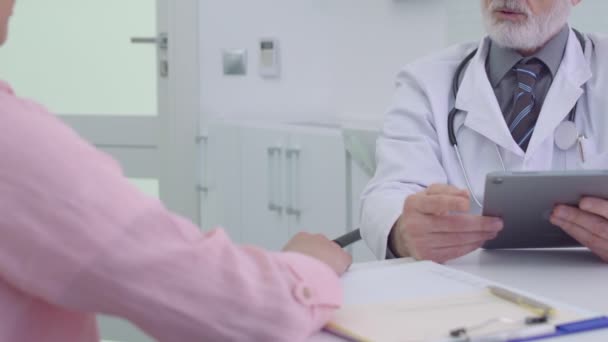 Médecin parlant au patient à la clinique, tenant le comprimé, diagnostic — Video