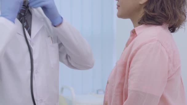 Médico cualificado en estetoscopio que examina el pecho del paciente, visita al médico — Vídeos de Stock